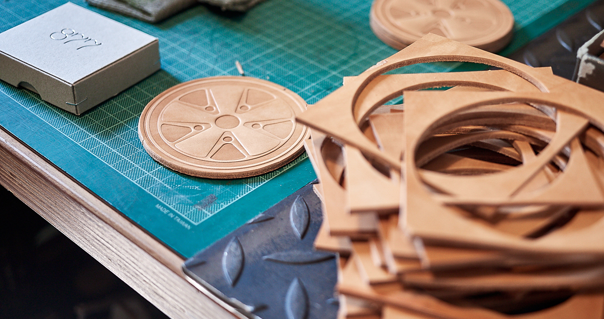 Leather coasters in the shape of a Porsche Wheel made by the 877 workshop