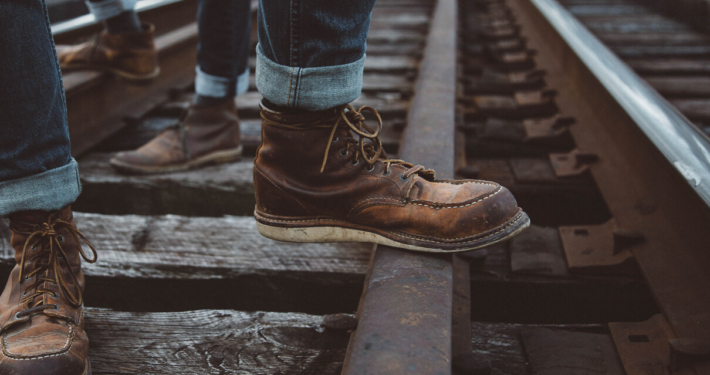Man standing on a railway track in a well work pair of Red Wing 875s