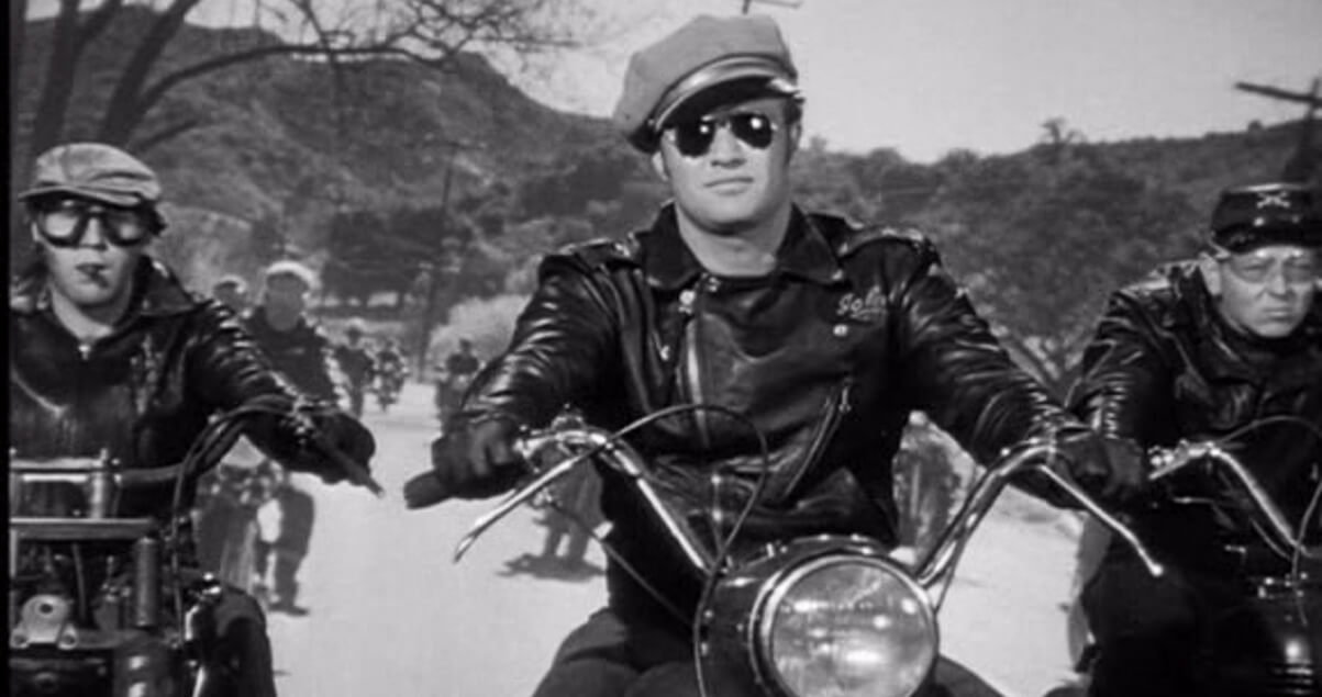 Marlon Brando in The Wild One riding into town wearing a schott perfecto