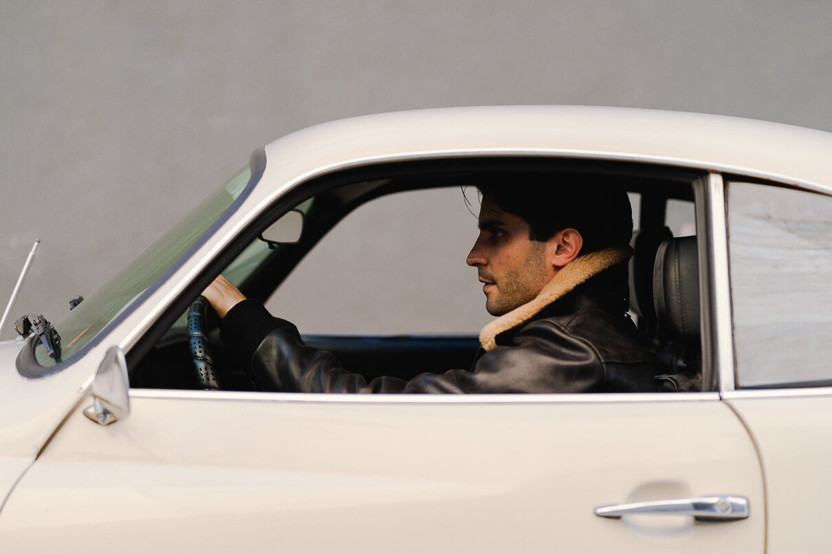 Man driving a car wearing the 3sixteen/Schott collaboration A-2 jacket