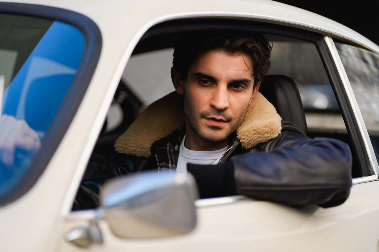 Man looking out the window of a car wearing the 3sixteen/Schott collaboration A-2 jacket