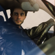Man behind the wheel of a car wearing the 3sixteen/Schott collaboration A-2 jacket