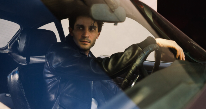 Man behind the wheel of a car wearing the 3sixteen/Schott collaboration A-2 jacket