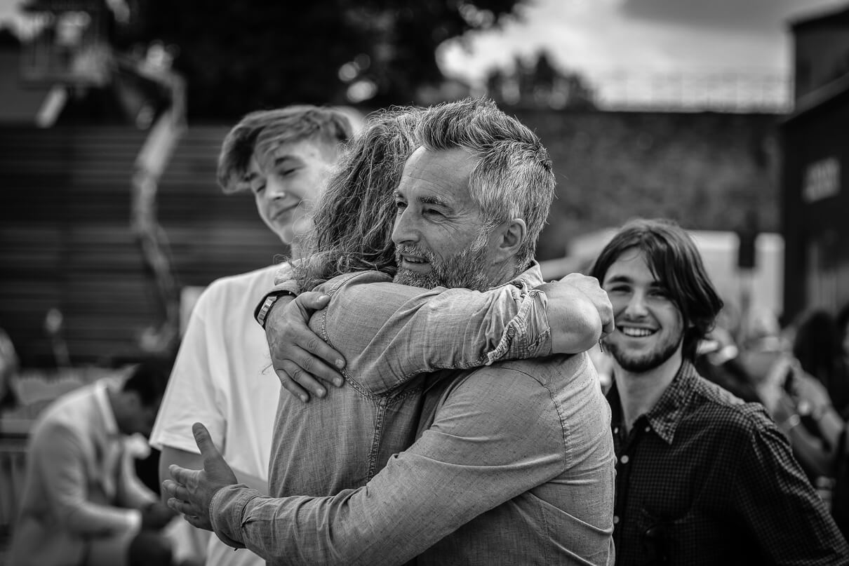 Two men hugging and greeting each other at the Pitti Uomo in Florence